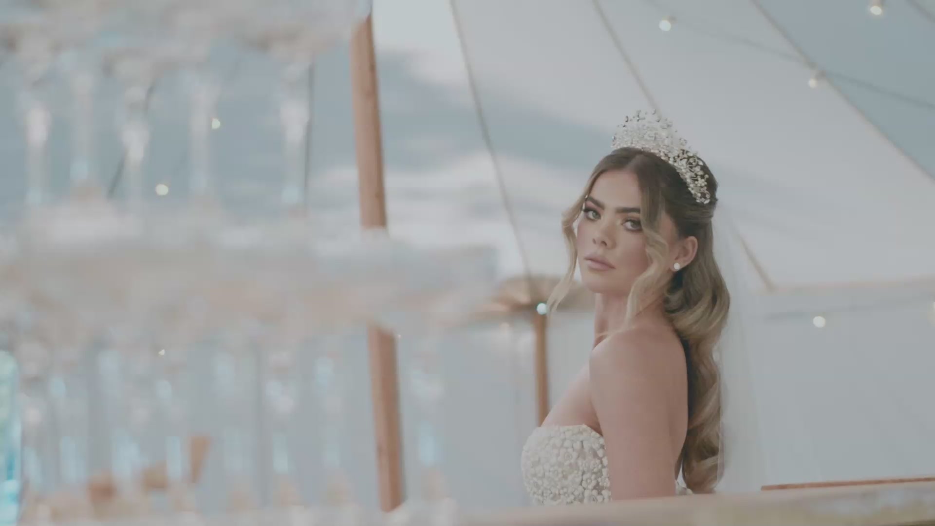 wedding crowns - a beautiful model wearing a stunning pearl and crystal bridal crown soft and ethereal. bride wearing a strapless wedding gown. bride is in a wedding marquee at brookleigh esttae