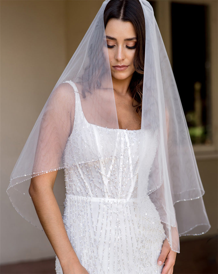 wedding and bridal veils - elegant elbow length veil with extra sparkle crystal edge - two tier - on model with dark hair - front view - Demi at Kezani