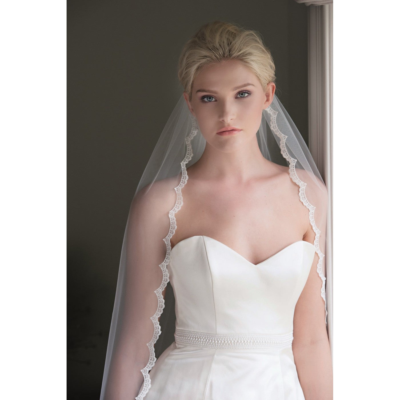 Bride in her white wedding gown with a white scallop lace edge veil called "Beauty" from Kezani jewellery.