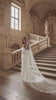 bride in a stunning renaissance building walking up the steps showing off her beautiful cathedral lace edge veil