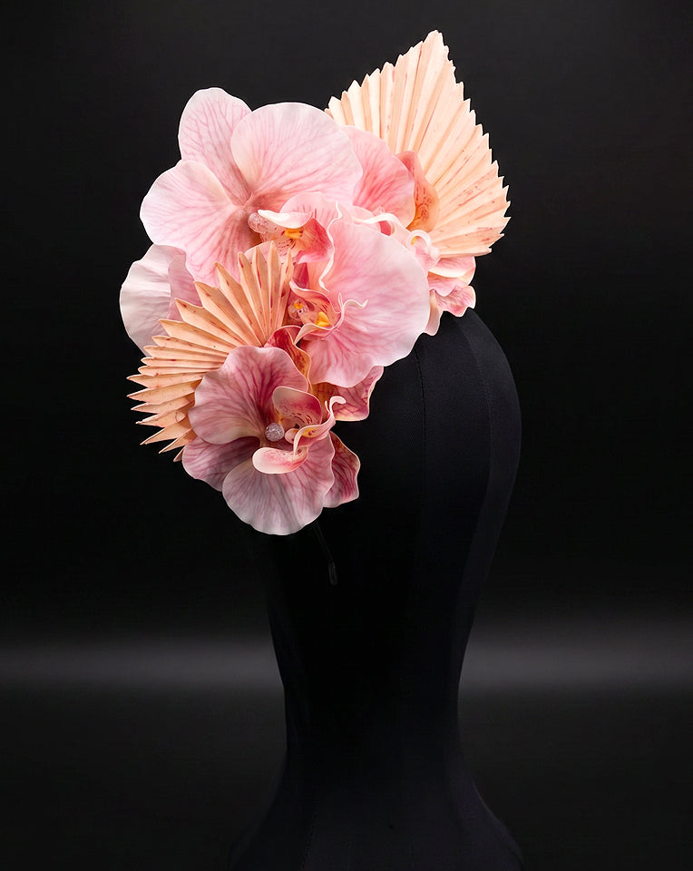side view of floral orchid and fan fascinator on black background
