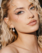 close up of blonde bride wearing dainty pearl and crysal earring