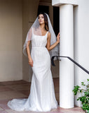 wedding and bridal veils - elegant elbow length veil with extra sparkle crystal edge - two tier - on model with dark hair - full length view - Demi at Kezani