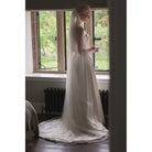 A bride full length veil scallop lace edge veil called "Beauty" from Kezani jewellery that gathers to a circle around her on the floor. 